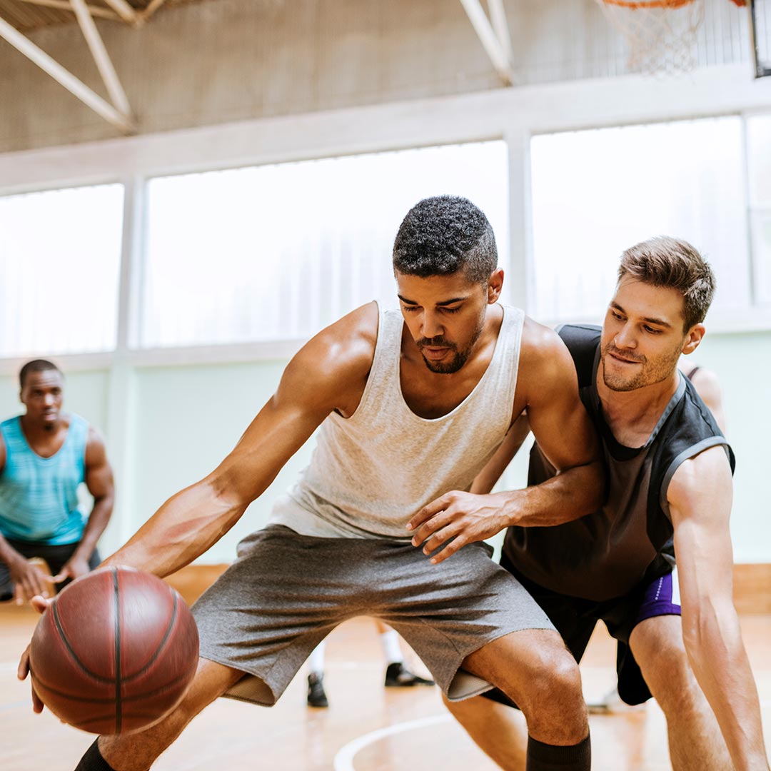 Young Men playing basketball indoors