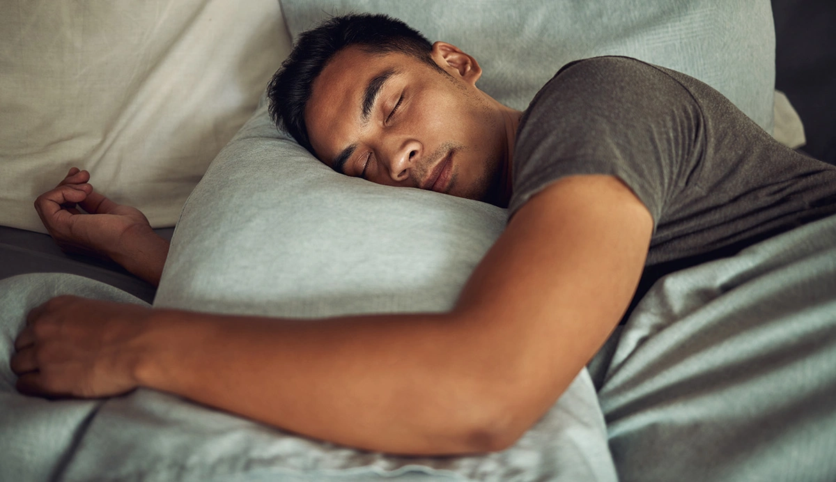 Man sleeping holding pillow