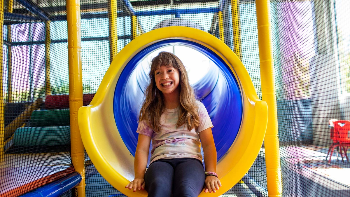 young girl on playscape slide