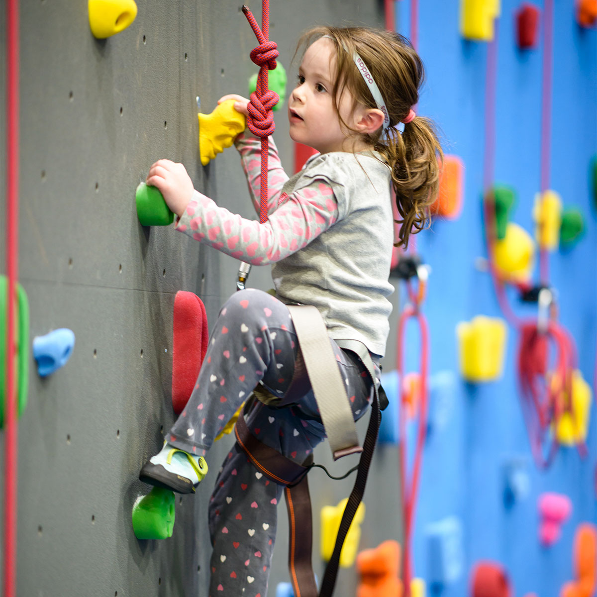 Little girl climbing a rock wall