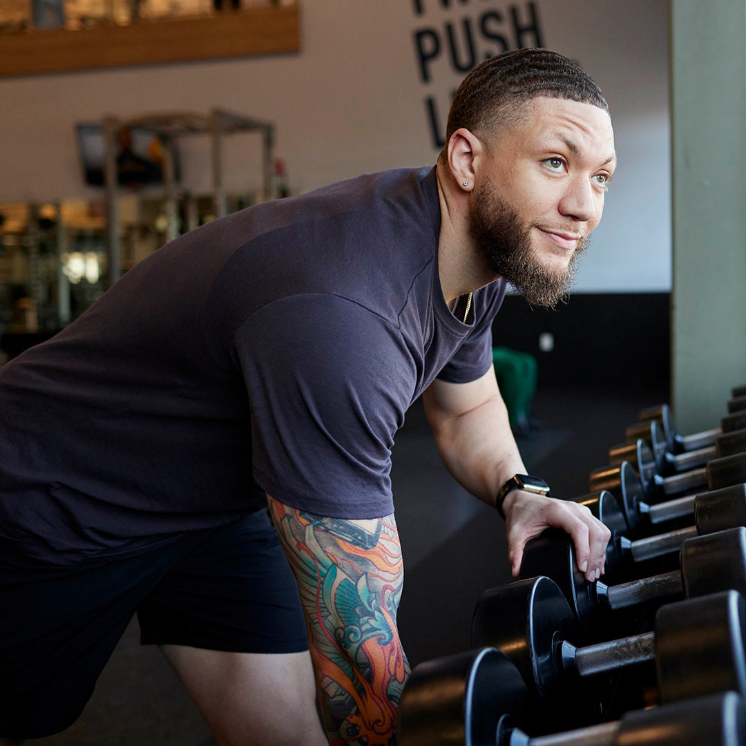 Man grabbing dumbell from rack